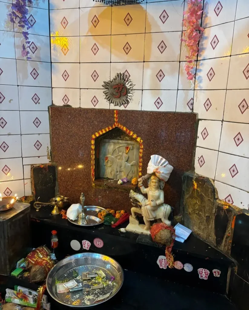 Golu Devta idol with offerings at Uttarakhand temple shrine.